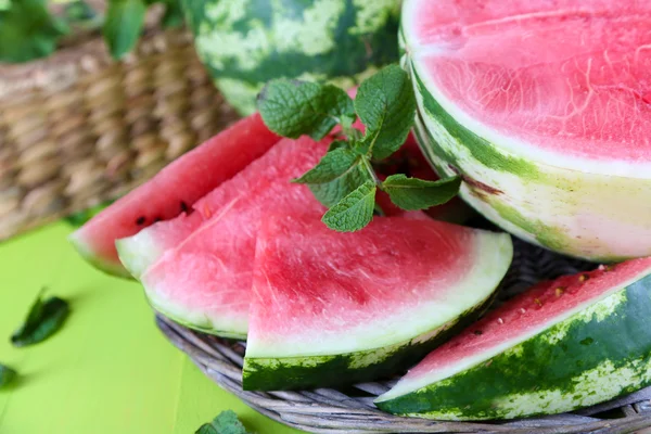 Ripe watermelons on wicker tray on wooden table — Stock Photo, Image