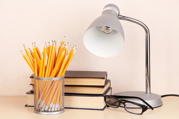 Настольная лампа с книгами на столе в комнате — стоковое фото