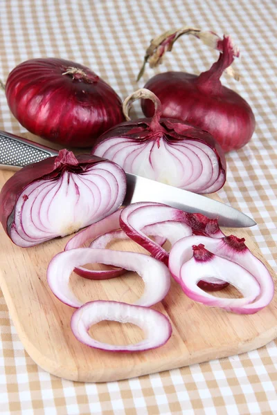 Cebollas rojas frescas en la tabla de cortar de cerca — Foto de Stock