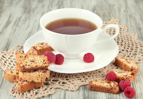 Чашка чаю з печивом і малиною на столі крупним планом — стокове фото
