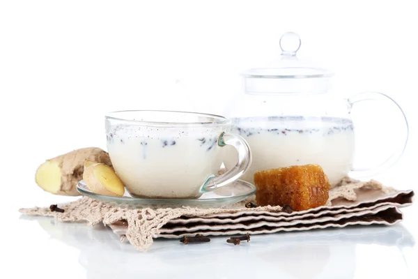 Théière et tasse de thé avec lait et épices sur serviette isolée sur blanc — Photo