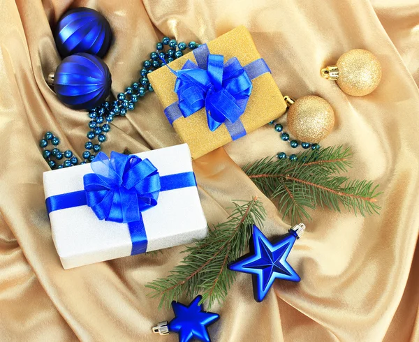 Красивые яркие подарки и рождественский декор, на шелковой ткани — стоковое фото