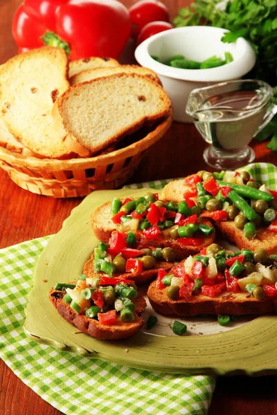 木製のテーブルのクローズ アップの皿の上の緑と野菜のサンドイッチ — ストック写真