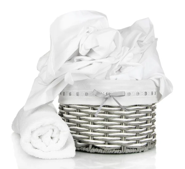 Rumpled bedding sheets in wicker basket isolated on white — Stock Photo, Image