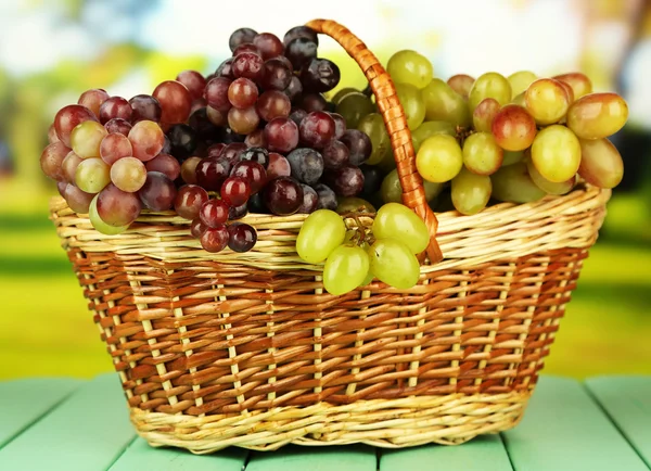 在明亮的背景上的柳条垫上的新鲜葡萄 — 图库照片