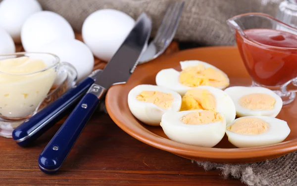 Huevos cocidos en plato sobre tabla de madera sobre mantel sobre mesa de madera —  Fotos de Stock