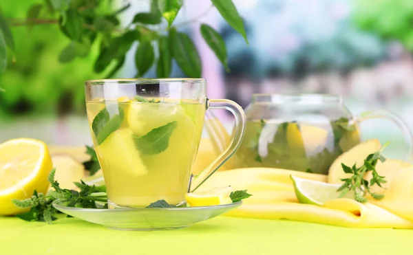 Cup of tea with ginger on wooden table on nature background — Stock Photo, Image