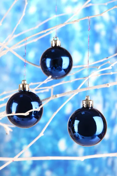 Weihnachtsspielzeug hängt am Ast auf blauem Hintergrund — Stockfoto