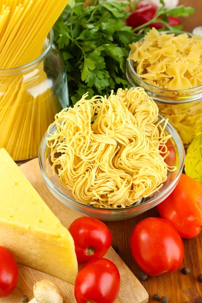 Pasta with oil, cheese and vegetables on wooden table close-up — Stock Photo, Image