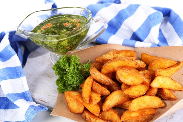 Home potatoes on tracing paper on wooden board near napkin isolated on white — Stock Photo, Image