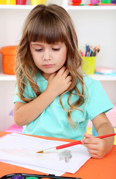 Liten flicka ritar sittande vid bord närbild — Stockfoto