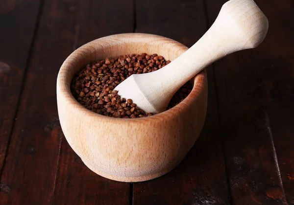 Buckwheat groats in bowl on wooden background — Stock Photo, Image