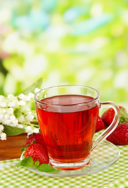 Delicioso té de fresa en la mesa sobre fondo brillante — Foto de Stock