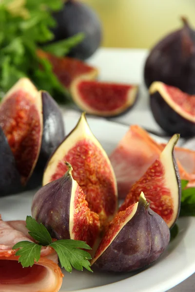 Tasty figs with ham on plate