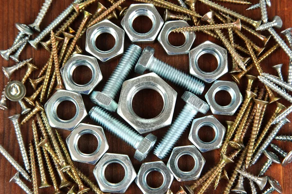 Bolts, screws and nuts on wooden table — Stock Photo, Image