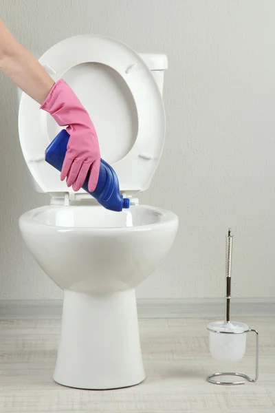 Mano de mujer con botella de spray limpiando un inodoro en un baño — Foto de Stock