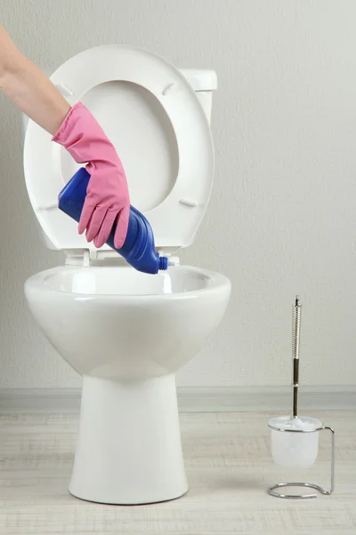 Frau Hand mit Sprühflasche reinigt Toilettenschüssel im Badezimmer — Stockfoto