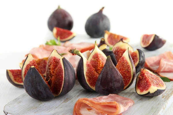 Figues savoureuses avec jambon sur table en bois blanc — Photo