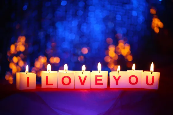 Candles with printed sign I LOVE YOU,on blur lights background — Stock Photo, Image