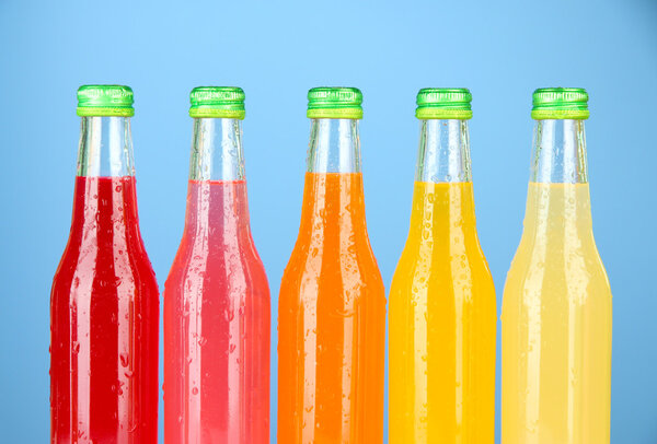 Bottles with tasty drinks on bright background