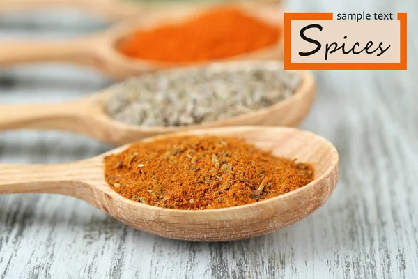 Assortment of spices in wooden spoons on wooden background — Stock Photo, Image