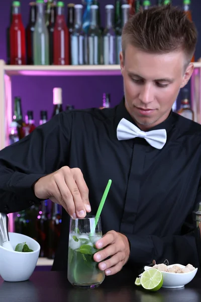 Portrait of handsome barman preparing cocktail, at bar — Stock Photo, Image