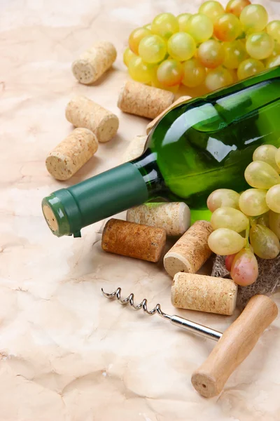 Botella de vino, uvas y corchos sobre papel viejo —  Fotos de Stock