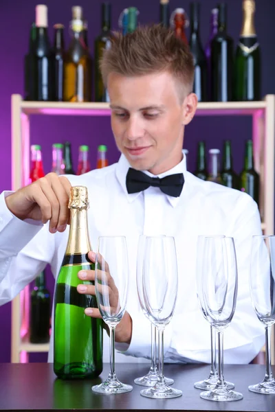 Barman está derramando champanhe em copos — Fotografia de Stock