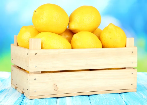 Ahşap kutusunda tablo parlak zemin üzerinde olgunlaşmış limon — Stok fotoğraf