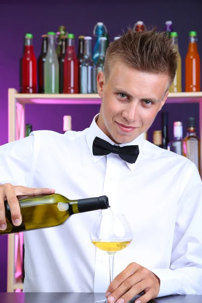 Bartender is pouring white wine into glass — Stock Photo, Image