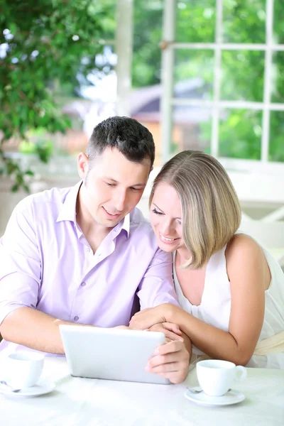 Casal jovem tirando foto com tablet no restaurante — Fotografia de Stock