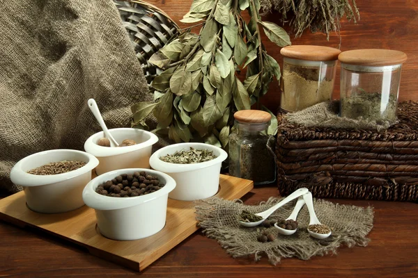 Sortiment av kryddor i vit skedar och skålar, på trä bakgrund — Stockfoto