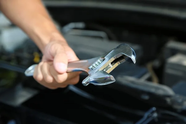 Mano con llave inglesa. Mecánico de automóviles en la reparación de automóviles — Foto de Stock