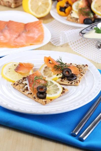 Lachssandwiches auf Teller auf Holztisch in Großaufnahme — Stockfoto