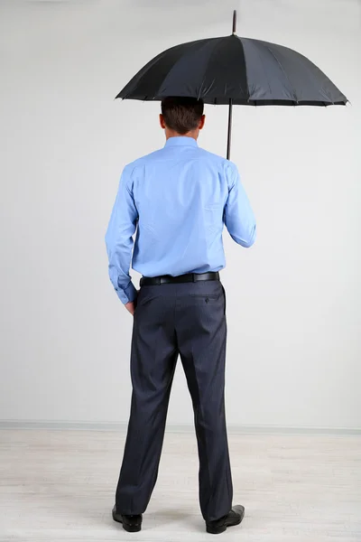 Geschäftsmann mit Regenschirm. auf grauem Hintergrund — Stockfoto