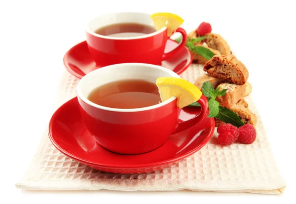 Tazze di tè con biscotti e lamponi isolati su bianco — Foto Stock