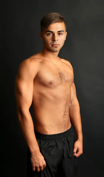 Porträt eines Muskelmannes auf grauem Hintergrund — Stockfoto