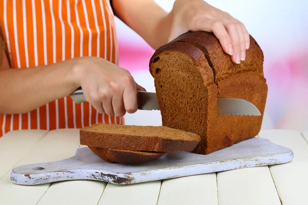 Parlak zemin üzerine ahşap masa ahşap tahta üzerinde ekmek kesme — Stok fotoğraf