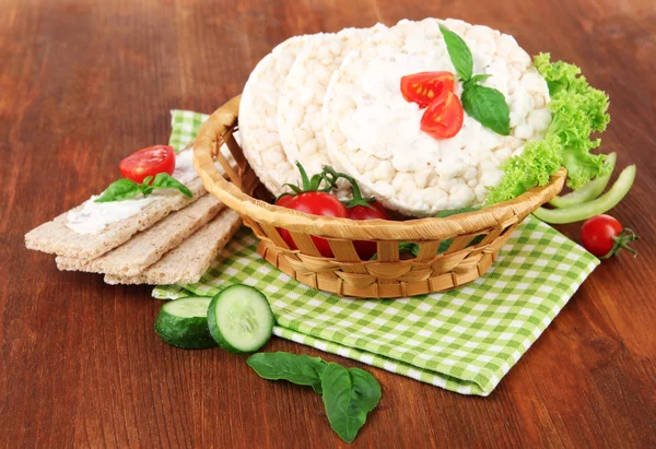 Tasty crispbreads with vegetables on wooden background — Stock Photo, Image