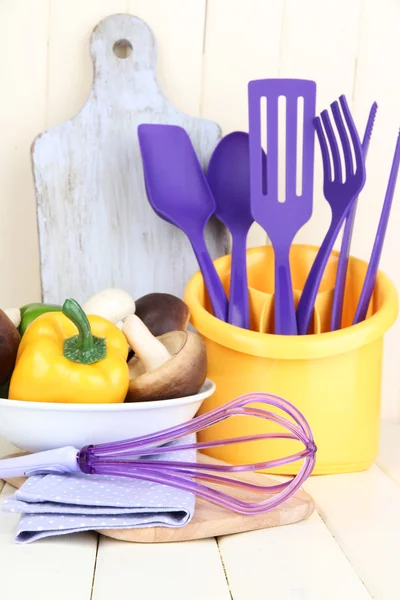 Utensili da cucina in plastica in tazza su tavolo di legno — Foto Stock