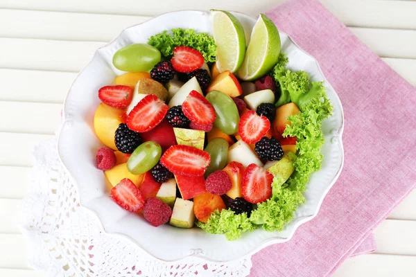 Fruktsallad i plattan på servett träbord — Stockfoto