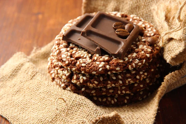 Hembakade kakor med sesamfrön, choklad, på träbord, på säckväv bakgrund — Stockfoto