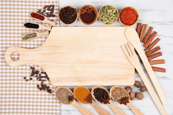 Verschillende kruiden en specerijen met leeg houten bord — Stockfoto