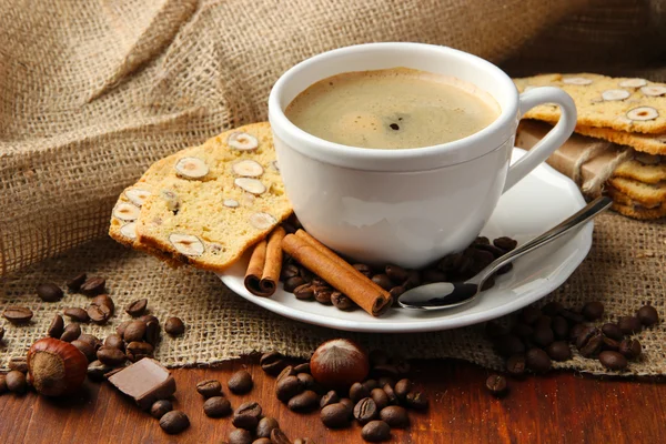 Tasse leckeren Kaffee mit leckeren italienischen Keksen, auf Holzgrund — Stockfoto