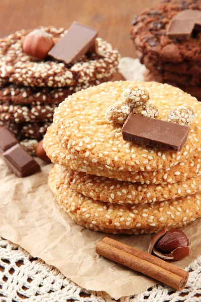 Zelfgemaakte koekjes met sesamzaad, chocolade, op servet, op houten achtergrond — Stockfoto