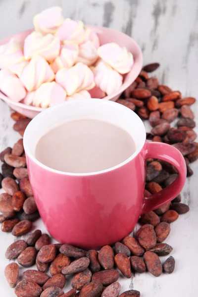 Cacao drank met specerijen, zephyr en cacaobonen op houten achtergrond — Stockfoto