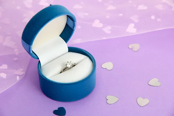 Caixa bonita com anel de casamento no fundo roxo Imagens Royalty-Free