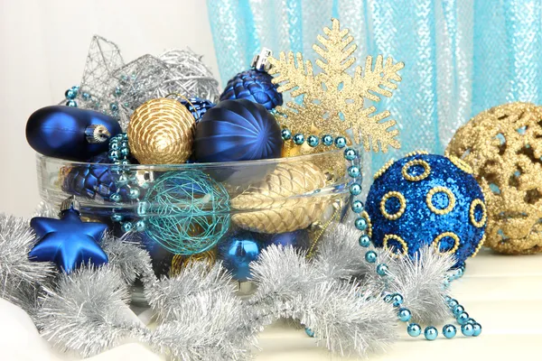 Рождественские украшения в стеклянной вазе на фоне ткани — стоковое фото