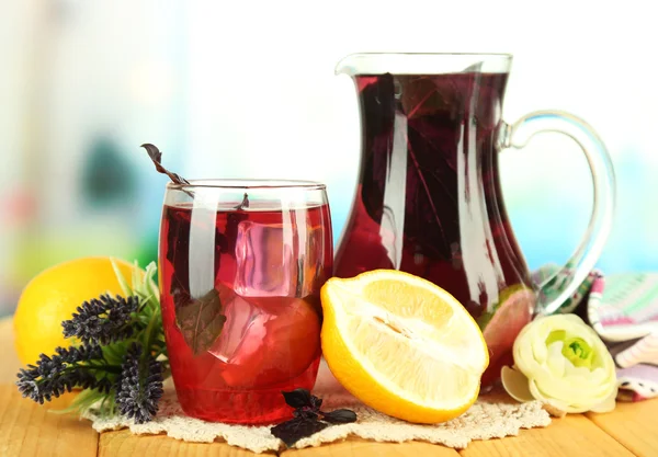 Rode basilicum limonade in kruik en glas, op houten tafel, op lichte achtergrond — Stockfoto