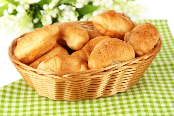 Tasty croissants in wicker basket on table on white background — Stock Photo, Image